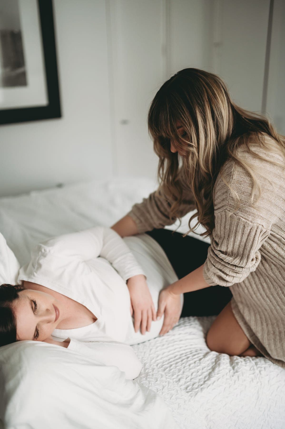 Vero supporting a pregnant client lying on her side.