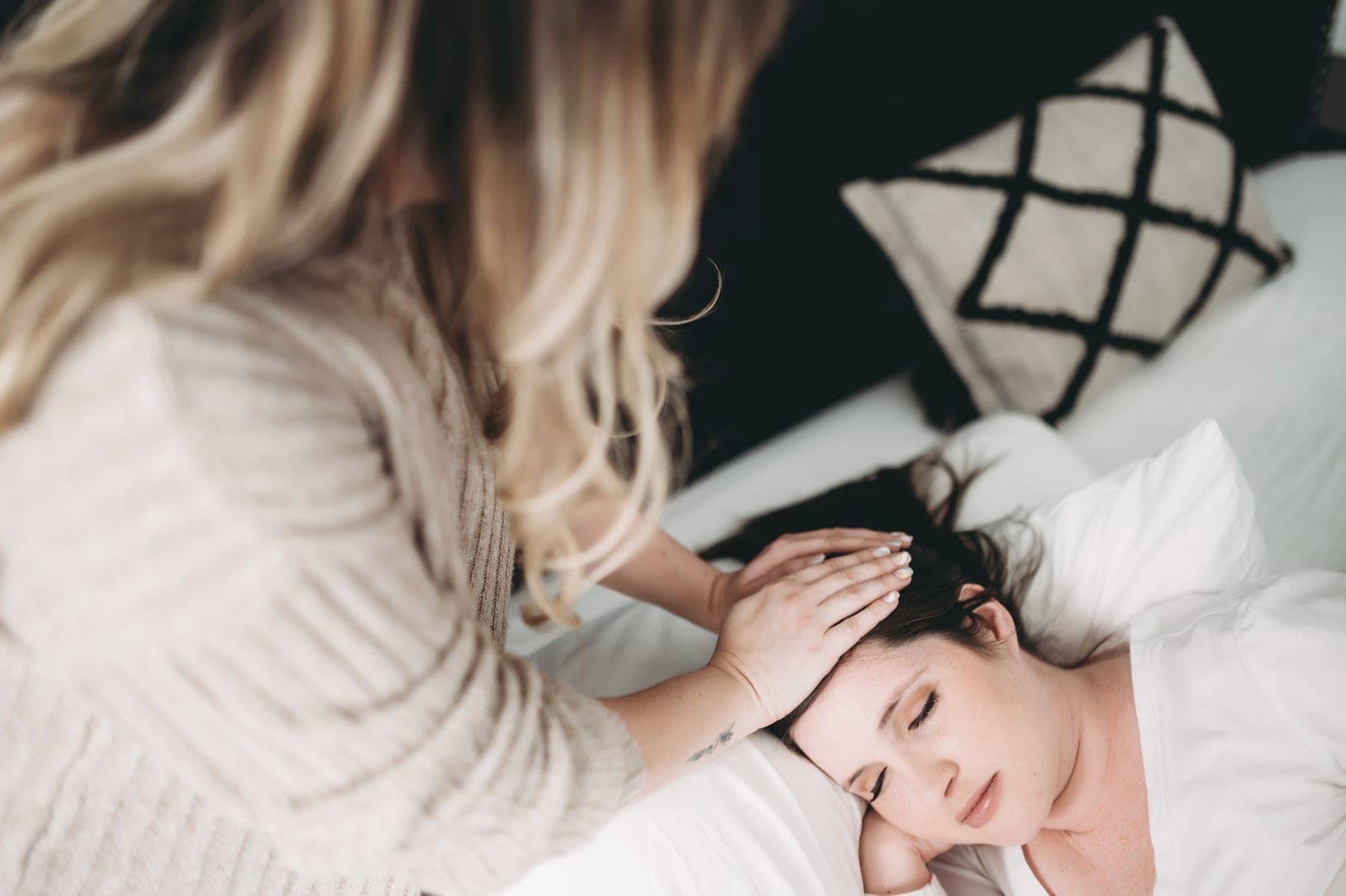 Vero's hands resting gently on a client's head during a Reiki session.